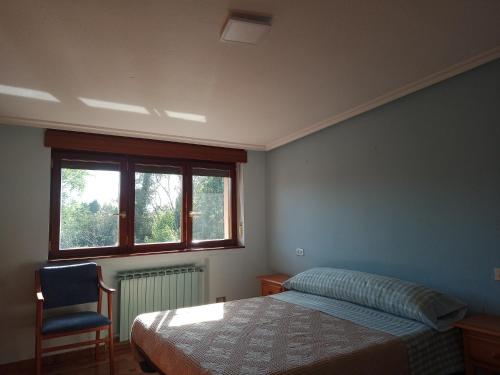 1 dormitorio con 1 cama, 1 silla y 1 ventana en Pensión ** Abacá Gijón en Gijón