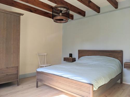 une chambre avec un grand lit avec une tête de lit en bois dans l'établissement Maison familiale paisible - Proche du Grand Mont, à Saint-Gildas-de-Rhuys