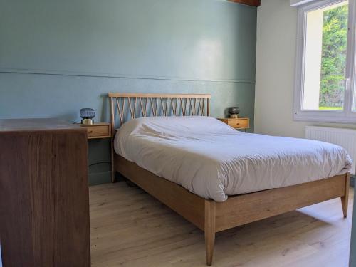 - une chambre avec un lit avec un cadre en bois et une fenêtre dans l'établissement Maison familiale paisible - Proche du Grand Mont, à Saint-Gildas-de-Rhuys