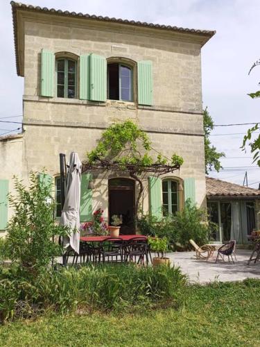 une maison avec une table et un parasol devant elle dans l'établissement Maison familiale - centre d'Uzès, à Uzès