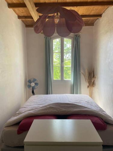 - une chambre avec un lit, une fenêtre et un ventilateur dans l'établissement Maison familiale - centre d'Uzès, à Uzès