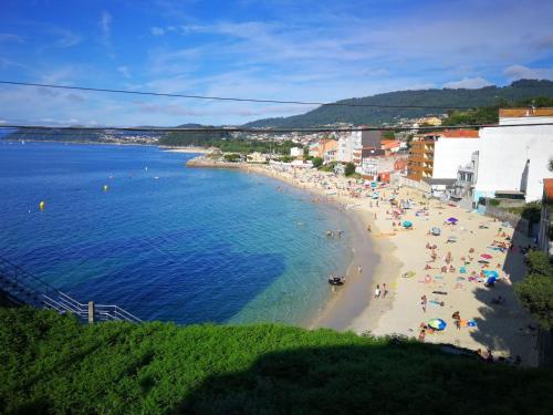 a group of people on a beach with the ocean at Alojamiento en Bueu (Loureiro) in Bueu