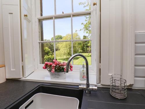a kitchen sink with a window and a flower pot at The Garden Apartment in Yarm