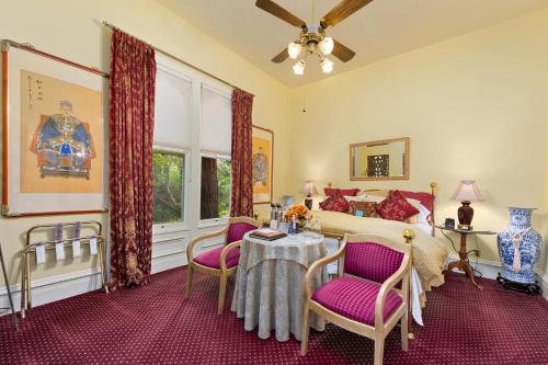 a bedroom with a bed and a table and chairs at The Gables Wine Country Inn in Santa Rosa