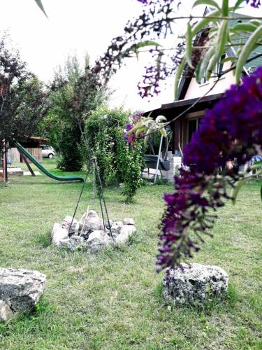 a garden with rocks and purple flowers and a swing at Panna tanya in Tahitótfalu