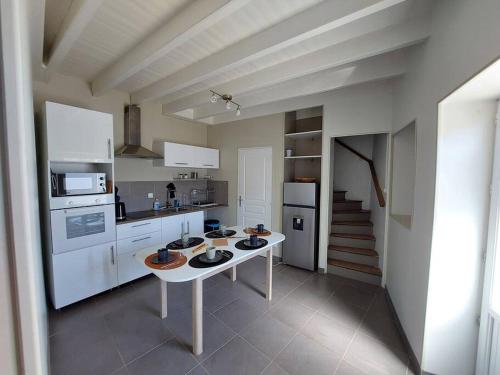 une cuisine avec une table au milieu dans l'établissement La maisonnette du marais, à Fontaines