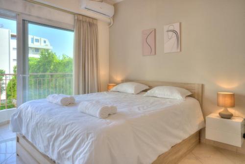 a bedroom with a large white bed with towels on it at Luxurious 2-bedroom 100m2 Apartment in Elliniko in Athens