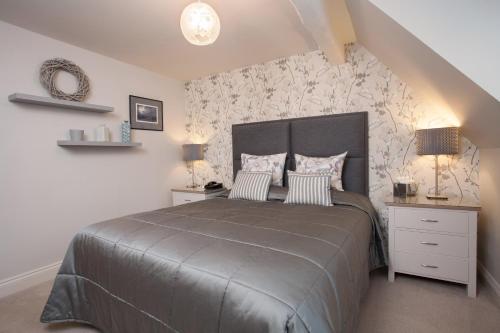 a bedroom with a large bed and two night stands at Orsett Hall in Orsett
