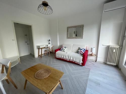 un salon avec un canapé rouge et une table dans l'établissement Les Geraniums, à Nice