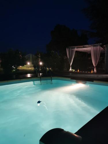 une piscine éclairée la nuit dans l'établissement Dépendance cosy entre jardin et jacuzzi privés et piscine partagée, à Aubagne
