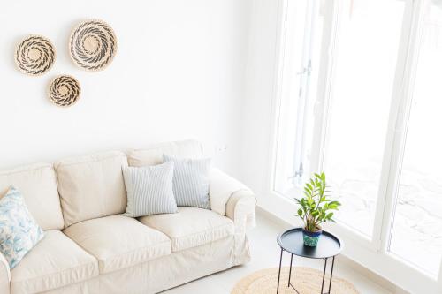 sala de estar con sofá blanco y mesa en Helona guesthouse, Skopelos, en Skopelos Town