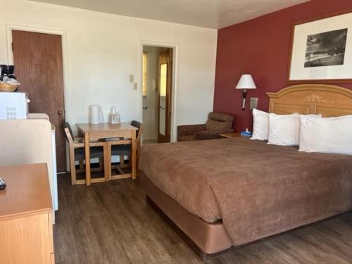 una camera d'albergo con un grande letto e una scrivania di Auto Inn Motel & RV Park a Newcastle