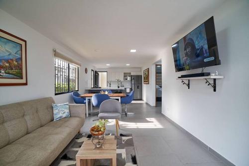 a living room with a couch and a tv on a wall at Monte Hermoso - Apartamento campestre in Guatapé