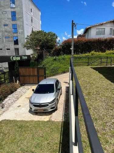 a silver car parked in a driveway next to a building at Monte Hermoso - Apartamento campestre in Guatapé
