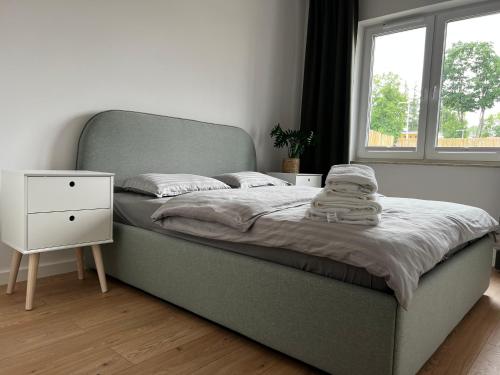 a bedroom with a bed with a night stand and a window at Apartament Iławka in Iława