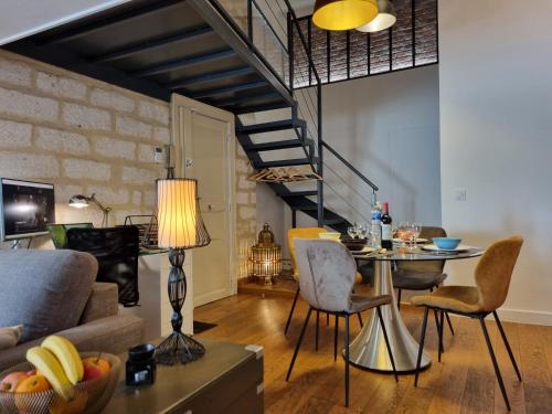a living room with a couch and a table with chairs at Duplex Chic Climatisé avec terrasse proche Comédie in Montpellier