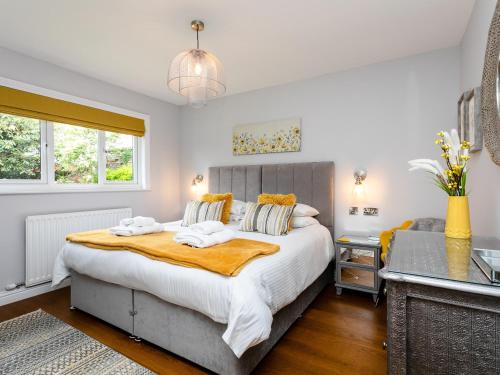 a bedroom with a large bed with two towels at Polished Pebble in Beadnell