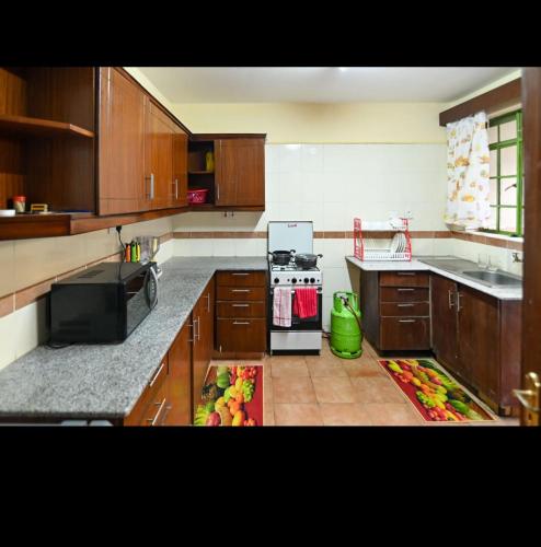 a kitchen with wooden cabinets and a counter with fruits on it at House 469 in Nairobi