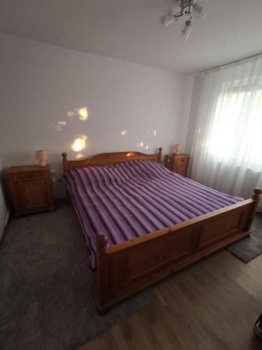 a bedroom with a large bed with purple sheets at Old Town Apartment 2 bedrooms, 1 living in Baia Mare