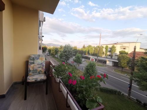 a balcony with a chair and flowers and a street at Old Town Apartment 2 bedrooms, 1 living in Baia Mare