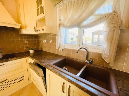 eine Küche mit einem Waschbecken und einem Fenster in der Unterkunft D & J Luxury House in Nea Kallikratia