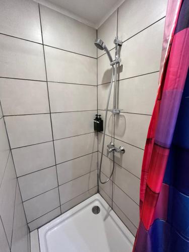 uma casa de banho com um chuveiro e uma banheira branca em Reeperbahn Apartments em Hamburgo