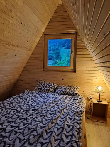 a bed in a wooden room with a window at Ozy's place in Kamnik