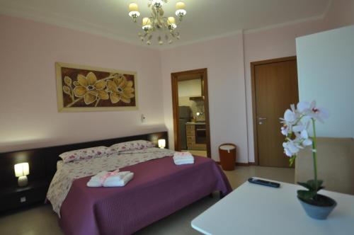 a bedroom with a bed with purple sheets and a table at Boat dreams , garden relax in Matino