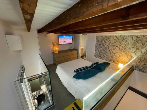 une petite chambre avec un lit et une télévision dans l'établissement Duplex Chic Climatisé avec terrasse proche Comédie, à Montpellier