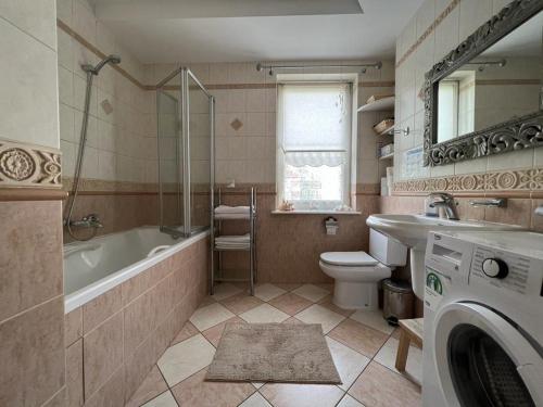 łazienka z wanną, toaletą i umywalką w obiekcie Comfort Zone Ostróda CITY & LAKE w Ostródzie
