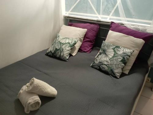 a bed with four pillows on top of it at APPARTEMENT 2 CHAMBRES A POINTE A PITRE in Pointe-à-Pitre