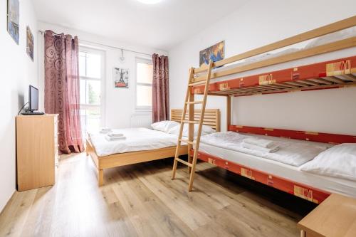 a bedroom with two bunk beds and a tv at Horský apartmán Temari 3 Klínovec in Loučná pod Klínovcem