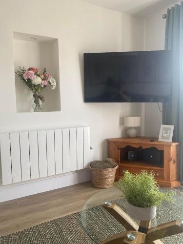 a living room with a flat screen tv on a wall at The Cwtch Pet Friendly Ground Floor Flat Near M4 and Porthcawl in Kenfig Hill