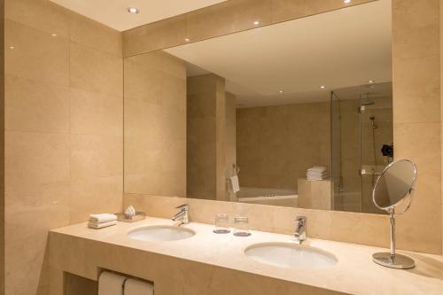 baño con 2 lavabos y espejo grande en Sheraton Miramar Hotel & Convention Center, en Viña del Mar