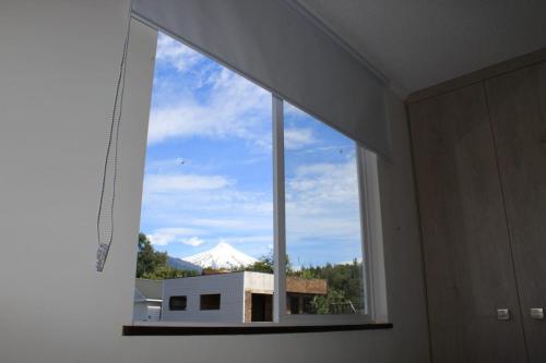 a window in a room with a view of a mountain at Casa Pucón in Pucón