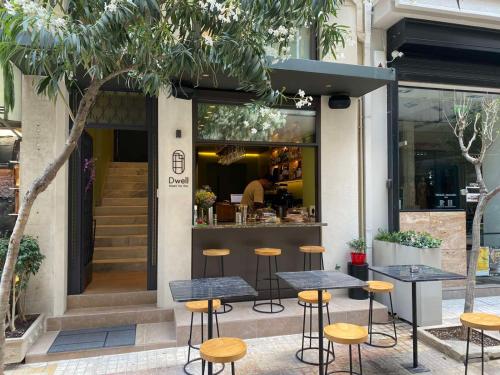 um restaurante com mesas e bancos em frente a uma loja em DWELL - Elegant City Stay em Atenas