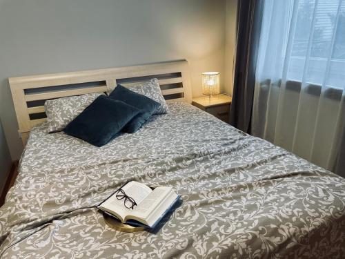 a bed with a book and pair of glasses on it at VillaAnita in Augustów