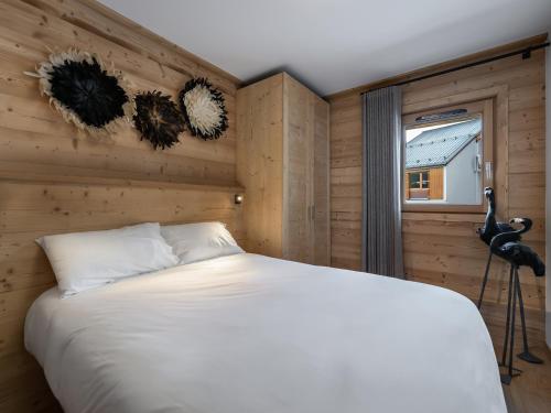 une chambre avec un lit blanc et une fenêtre dans l'établissement Appartement T4 à Courchevel, proche des pistes, avec terrasse, parking, et services inclus - FR-1-563-13, à Courchevel