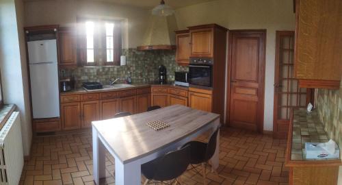 una cocina con armarios de madera y una mesa con sillas. en Gite 6 personnes Sarlat/Rocamadour, en CazoulÃ¨s