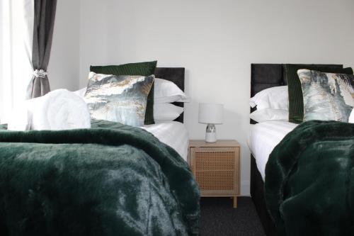 Duas camas sentadas uma ao lado da outra num quarto em Coventry Cosy Home - Perfect location for Contractors, Families, Relocators, close Walsgrave Hospital and Motorways em Wyken