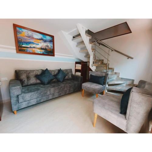 a living room with a couch and a staircase at Hotel Mansión Barichara in Barichara