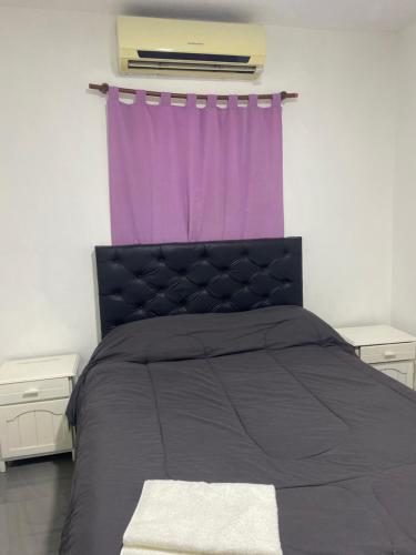 a bedroom with a bed with a purple curtain at La Vicenta in Deán Funes