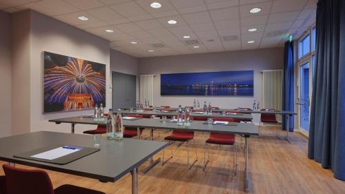 a room with tables and chairs and a large painting on the wall at Holiday Inn Express Düsseldorf - City North by IHG in Düsseldorf