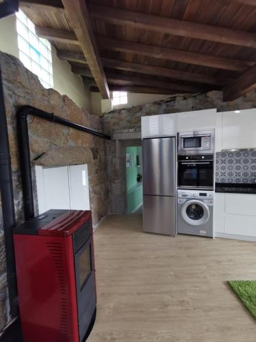 a kitchen with a refrigerator and a washer and dryer at O Recuncho de Tibias in Pereiro de Aguiar