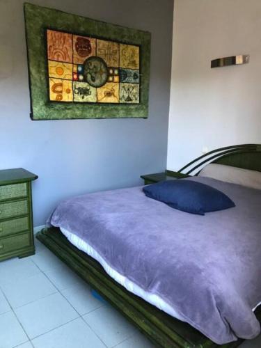 une chambre avec un lit et une horloge au mur dans l'établissement Maison familiale près de la mer, à Argelès-sur-Mer