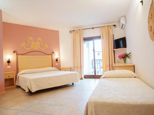 1 dormitorio con 2 camas y ventana en Hotel Pedra Santa en Baja Sardinia