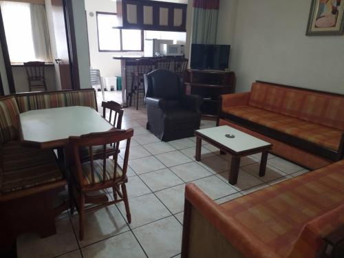 a living room with a couch and a table at Hotel Residencial Itapema in Itapema