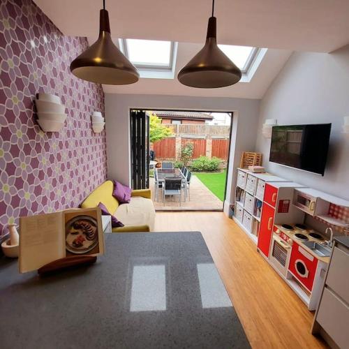 a living room with a kitchen and a living room with a tv at 3 bed Luxury Victorian Home with Hot Tub in Nottingham