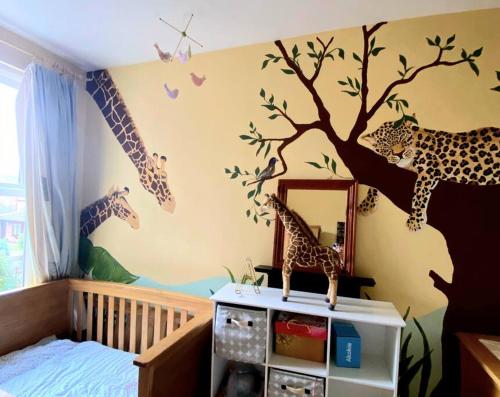 a childs bedroom with a giraffe mural on the wall at 3 bed Luxury Victorian Home with Hot Tub in Nottingham