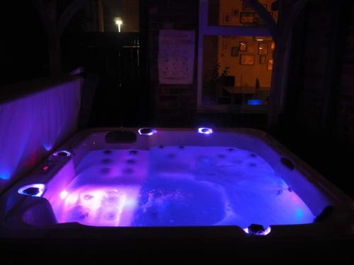 a bath tub with purple lights in a room at 3 bed Luxury Victorian Home with Hot Tub in Nottingham